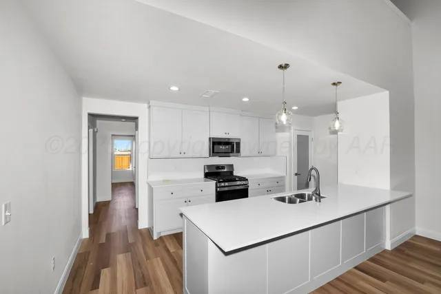 a kitchen with a sink stainless steel appliances and white cabinets