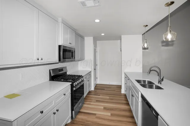 a kitchen with sink a stove and cabinets