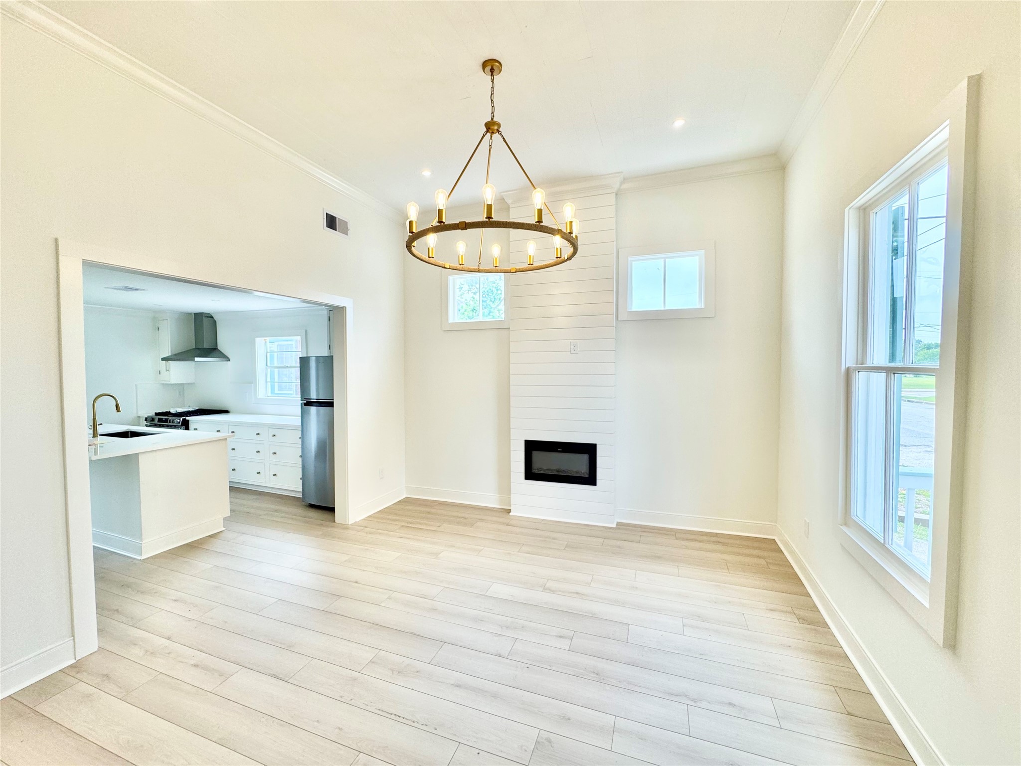 1312 35th Street Galveston, TX 77550 - Photo 6 of 32 a view of empty room with wooden floor and kitchen view