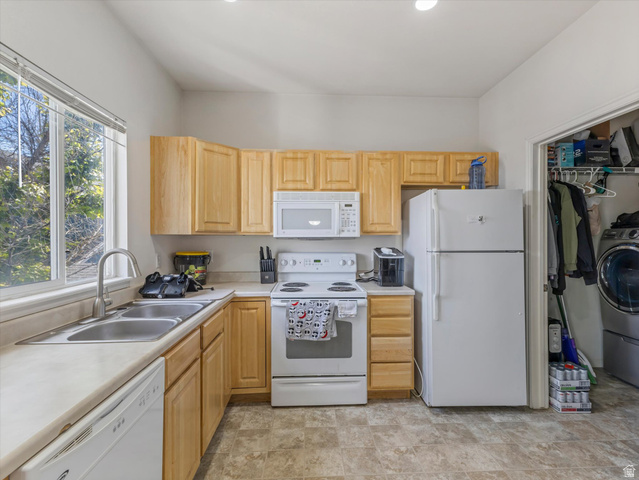 5038 West Red Shale Road Herriman, UT 84096 - Photo 4 of 16 Kitchen area featuring wood-finish cabinetry, white appliances, and a double basin stainless steel sink