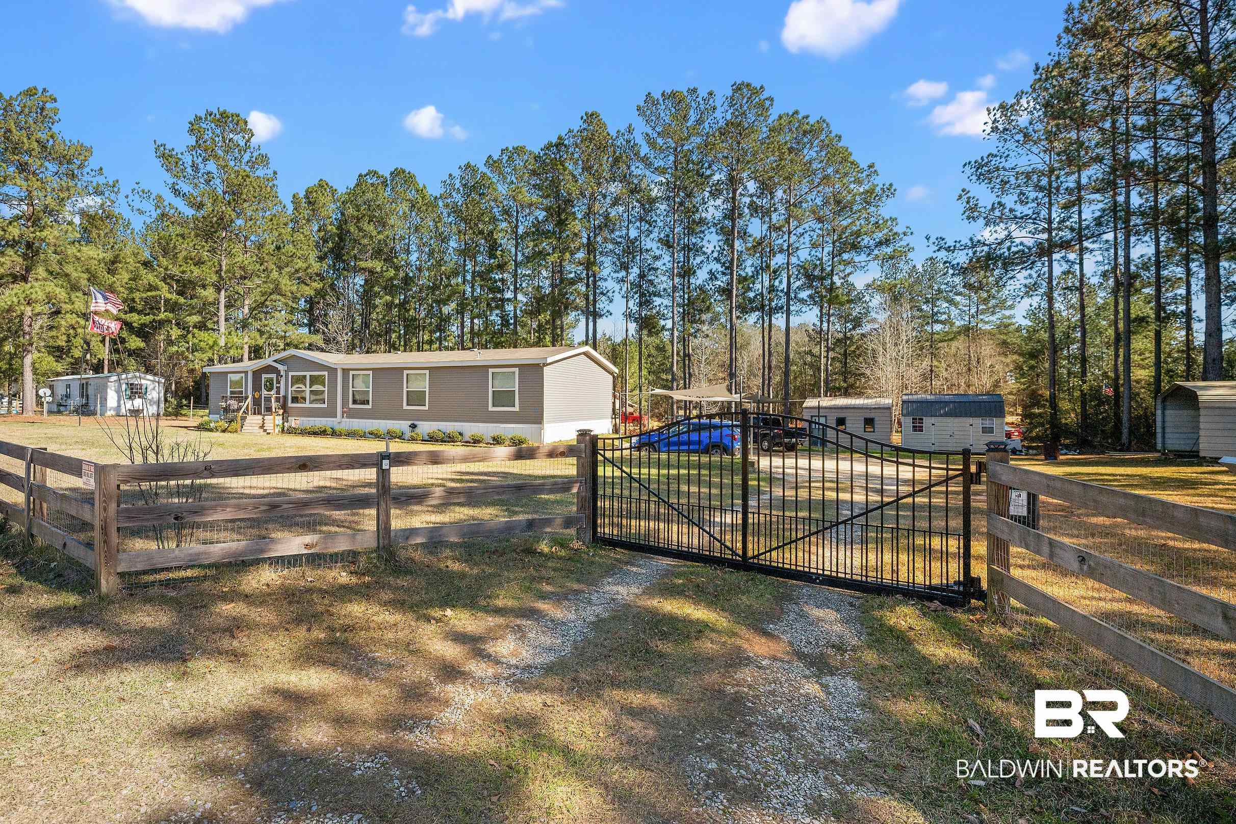 8630 Allison Lane Wilmer, AL 36587 - Photo 4 of 31 View of front of property featuring a gate and view of scattered trees