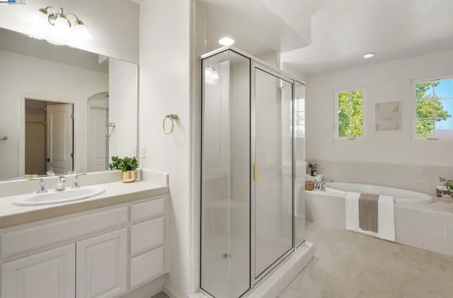 a bathroom with a double vanity sink toilet and shower