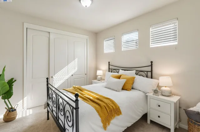 a bedroom with a bed and a potted plant