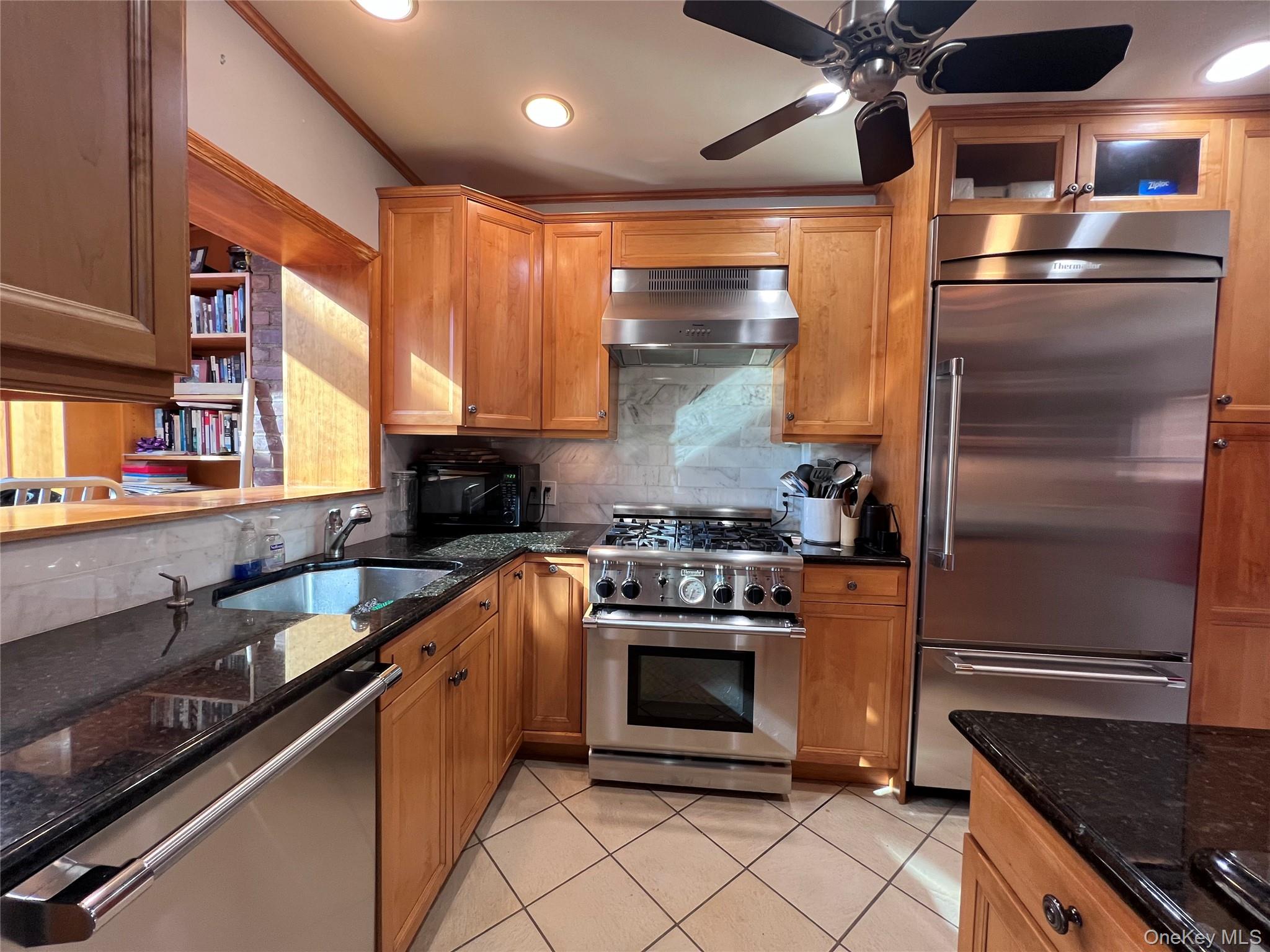 2561 Eastchester Road Bronx, NY 10469 - Photo 3 of 13 a kitchen with stainless steel appliances granite countertop a refrigerator a sink and a stove