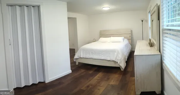 a bedroom with a bed and wooden floor