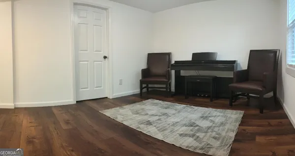 a view of a workspace with furniture and a wooden floor