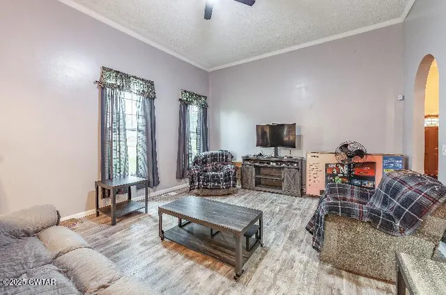 a living room with furniture a flat screen tv and a large window