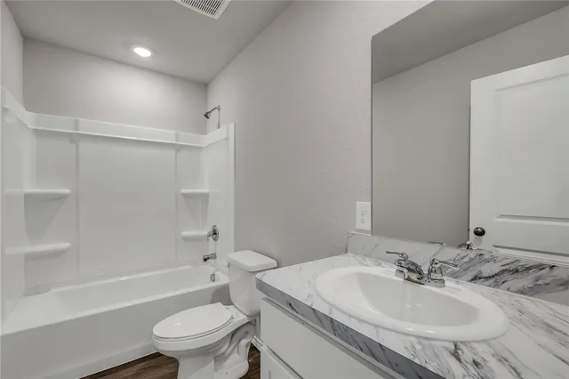 a bathroom with a sink toilet vanity and shower