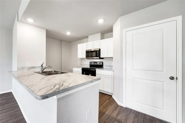 a kitchen with a sink a microwave a stove and refrigerator