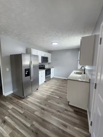 a kitchen with stainless steel appliances granite countertop a refrigerator and a sink