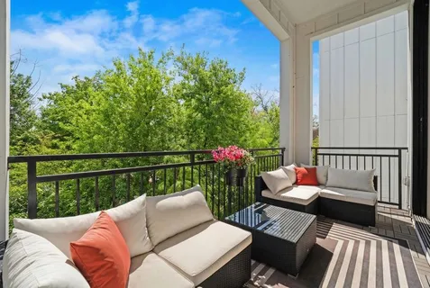 a balcony with wooden floor and outdoor seating