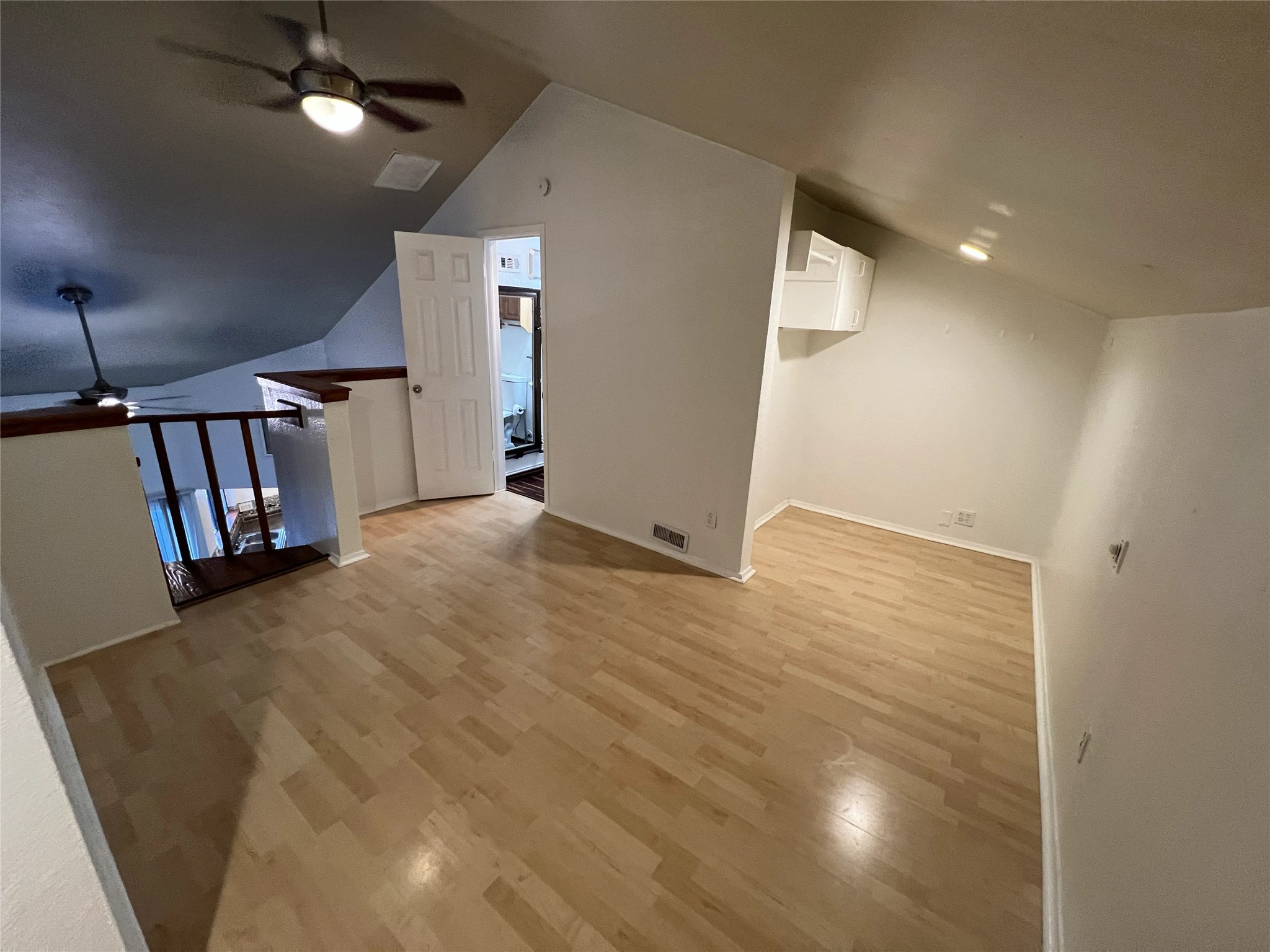 2500 Burleson Road, Unit 622 Austin, TX 78741 - Photo 11 of 17 A well-lit loft space showcases warm hardwood flooring and vaulted ceilings.