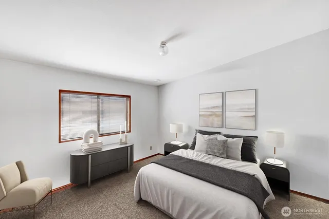 a bedroom with bed couch and window