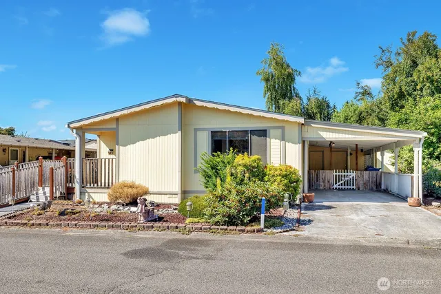 a front view of a house with a yard and potted plants