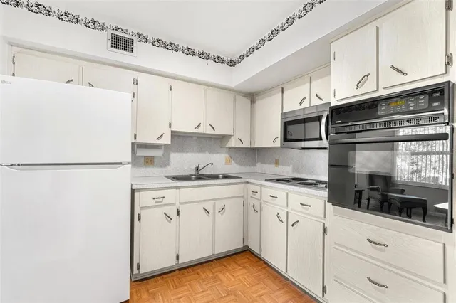 a kitchen with cabinets appliances a sink and a counter space
