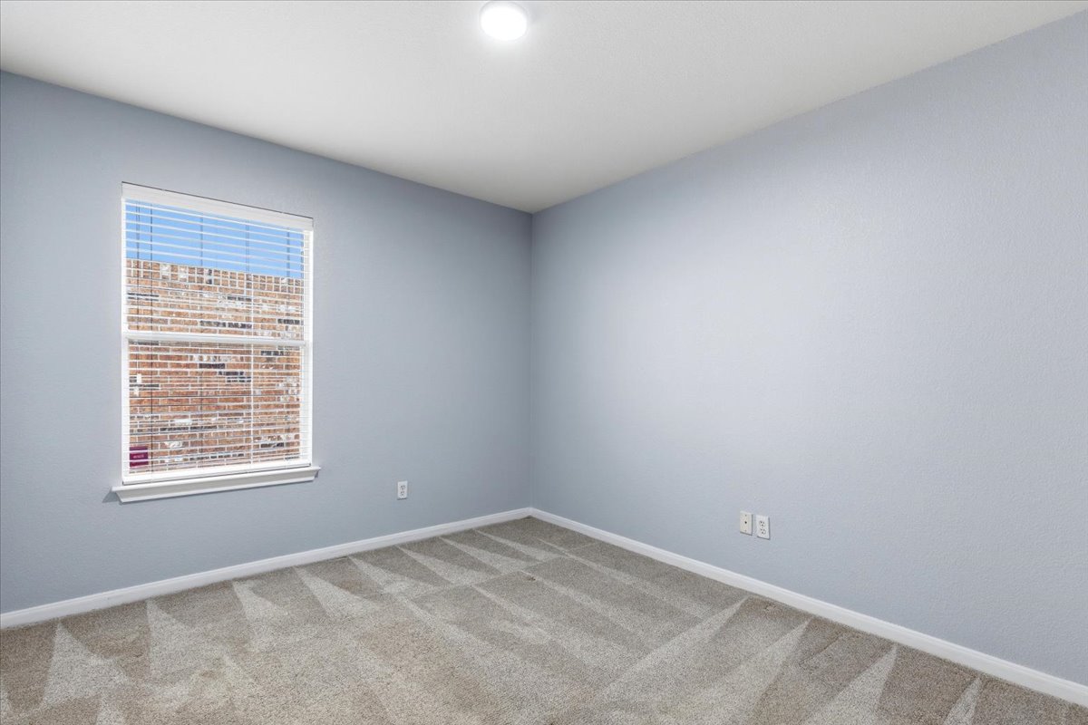 17812 Masi Loop Pflugerville, TX 78660 - Photo 26 of 38 Light gray carpeted room featuring a single window with horizontal blinds, light blue walls, white trim, and an overhead flush-mount light fixture
