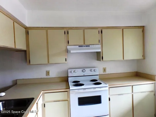 a kitchen with stainless steel appliances granite countertop a sink a stove and a microwave