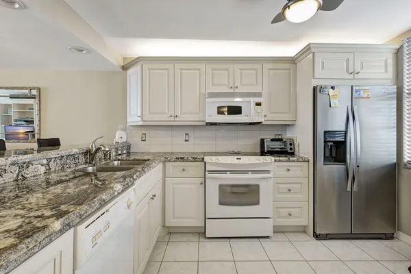 a kitchen with stainless steel appliances granite countertop a stove a sink and a refrigerator