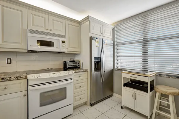 a kitchen with white cabinets stainless steel appliances and sink