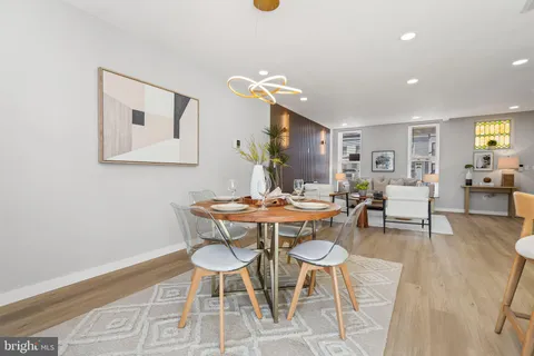 a kitchen with stainless steel appliances a sink dishwasher a refrigerator a stove and white cabinets with wooden floor