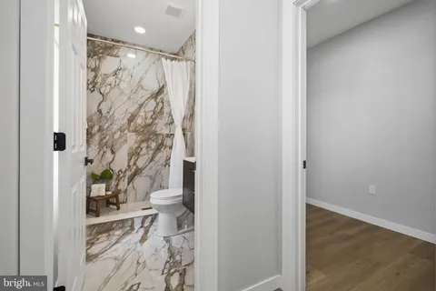 a bathroom with a sink a toilet a mirror a vanity and shower