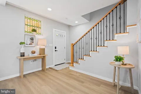 a living room with furniture and a dining table with wooden floor
