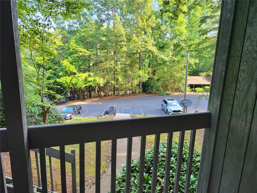 150 Ligon Street, Unit 1001 Clemson, SC 29631 - Photo 2 of 29 A tranquil balcony provides a verdant vista of towering trees and a quiet parking area.