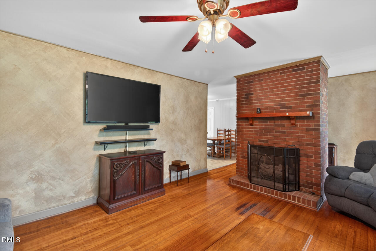 1420 Goodwin Road Durham, NC 27712 - Photo 10 of 54 a living room with furniture a flat screen tv and a fireplace