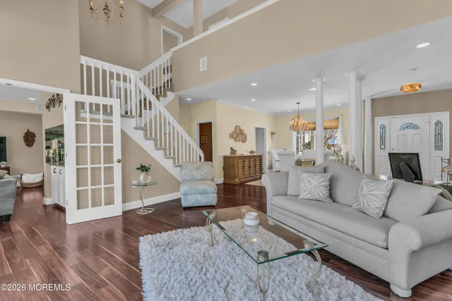 a kitchen with stainless steel appliances granite countertop a refrigerator a stove and a sink with wooden floor