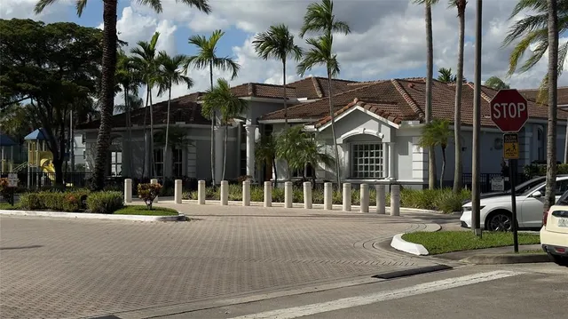 a view of a brick building with a yard and plants