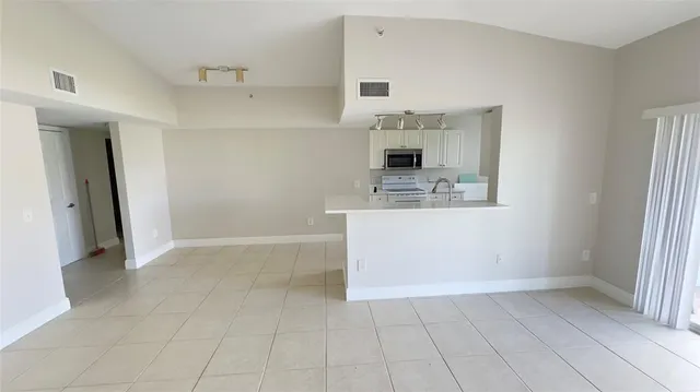a view of kitchen with refrigerator and window