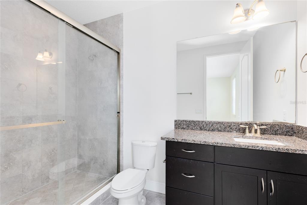 13969 Arclid Street Orlando, FL 32832 - Photo 14 of 29 a bathroom with a granite countertop sink toilet and shower