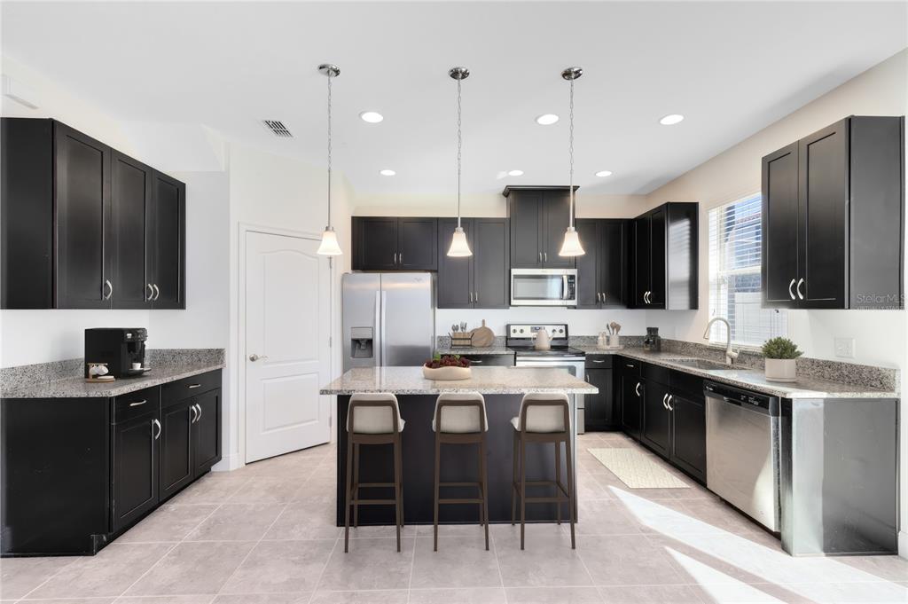 13969 Arclid Street Orlando, FL 32832 - Photo 2 of 29 a large kitchen with cabinets table and chairs