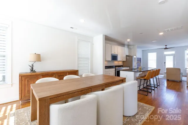 a living room with stainless steel appliances kitchen island furniture and wooden floor