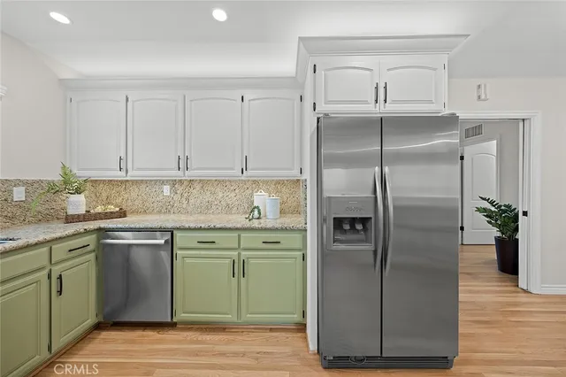 a kitchen with stainless steel appliances granite countertop a refrigerator and a sink
