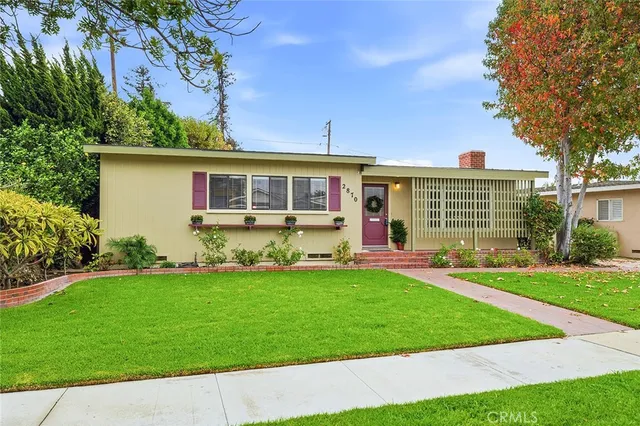 a front view of a house with a yard and outdoor seating