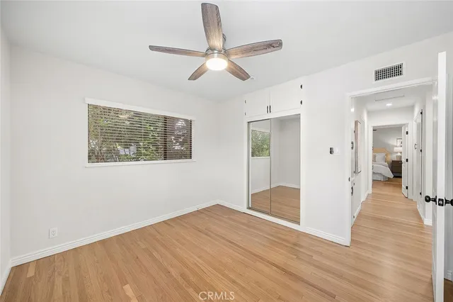 a view of a big room with wooden floor and a ceiling fan