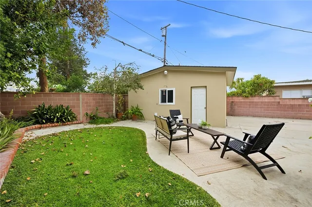 a view of a house with backyard and sitting area