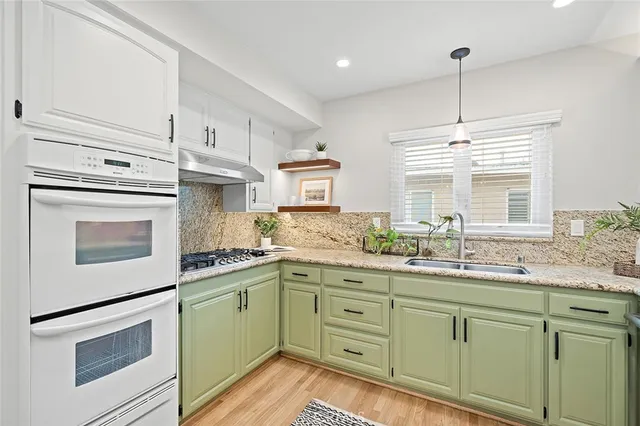 a kitchen with granite countertop cabinets stainless steel appliances and a sink