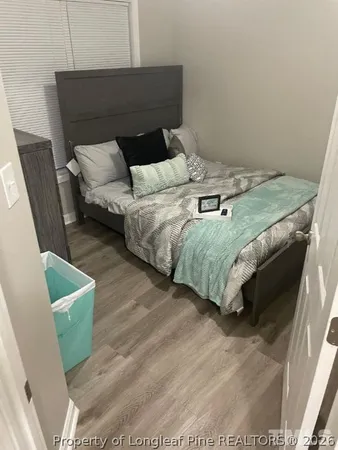 a bed sitting in a bedroom next to a window with wooden floor