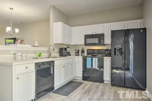 a kitchen with granite countertop a refrigerator stove and sink