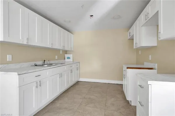 a kitchen with granite countertop white cabinets and sink