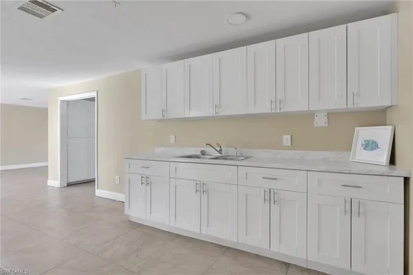 a kitchen with granite countertop white cabinets and sink