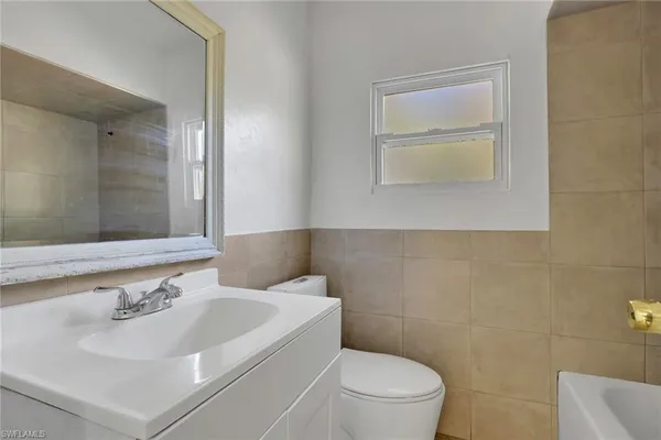 a bathroom with a sink a toilet and a mirror