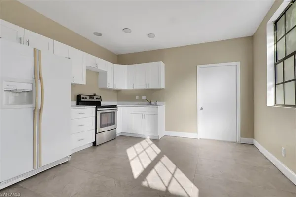 a kitchen with white cabinets and white appliances