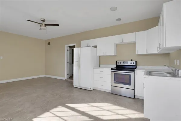 a kitchen with stainless steel appliances a refrigerator stove and white cabinets