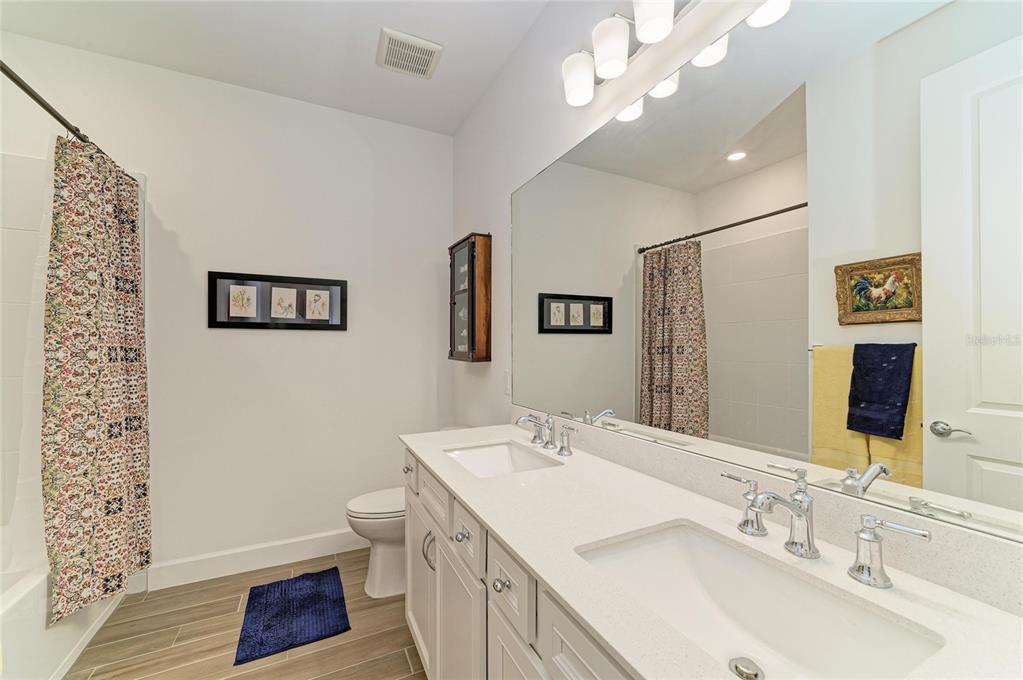 16341 Hidden Oak Loop Lakewood Ranch, FL 34211 - Photo 37 of 76 a bathroom with a sink a toilet a mirror and shower