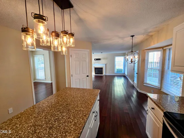 a view of a hallway with wooden floor and chandelier