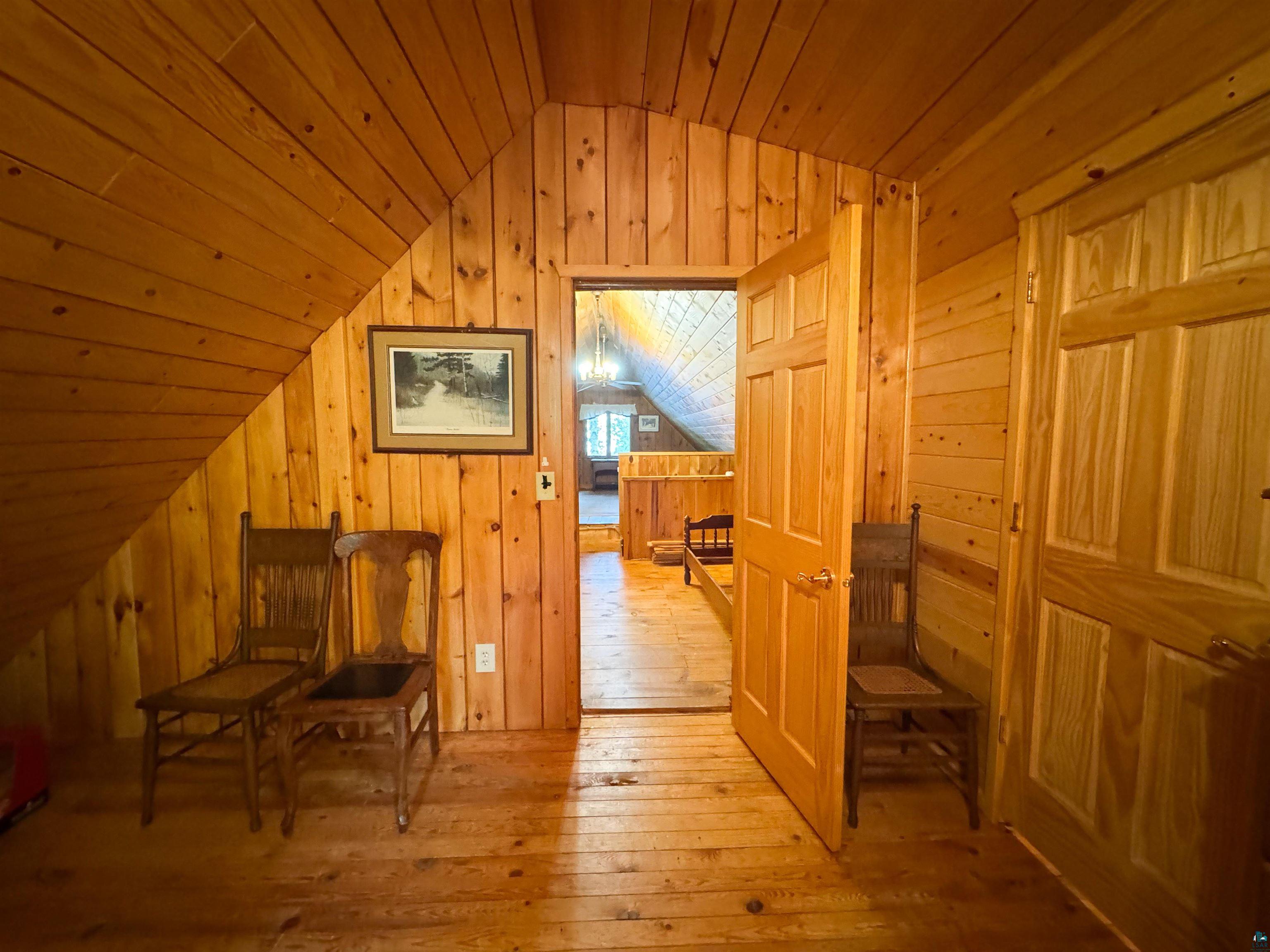 465 South Gunflint Lake Road Grand Marais, MN 55604 - Photo 41 of 46 Wood-finish flooring throughout, complemented by wood-paneled walls and a sloped wood-paneled ceiling