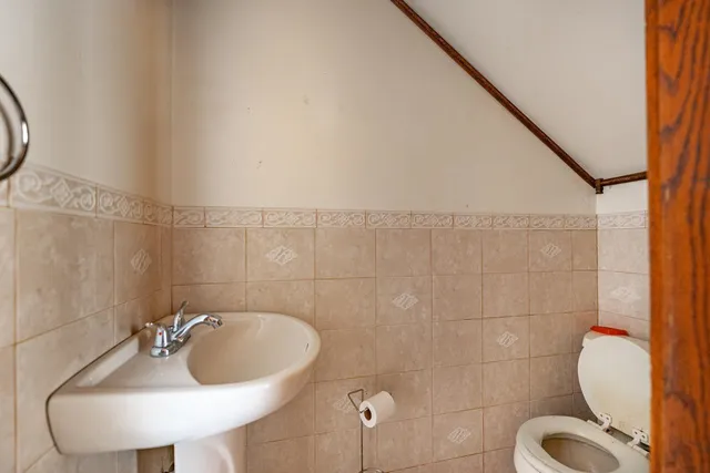 a bathroom with a sink and mirror with toilet